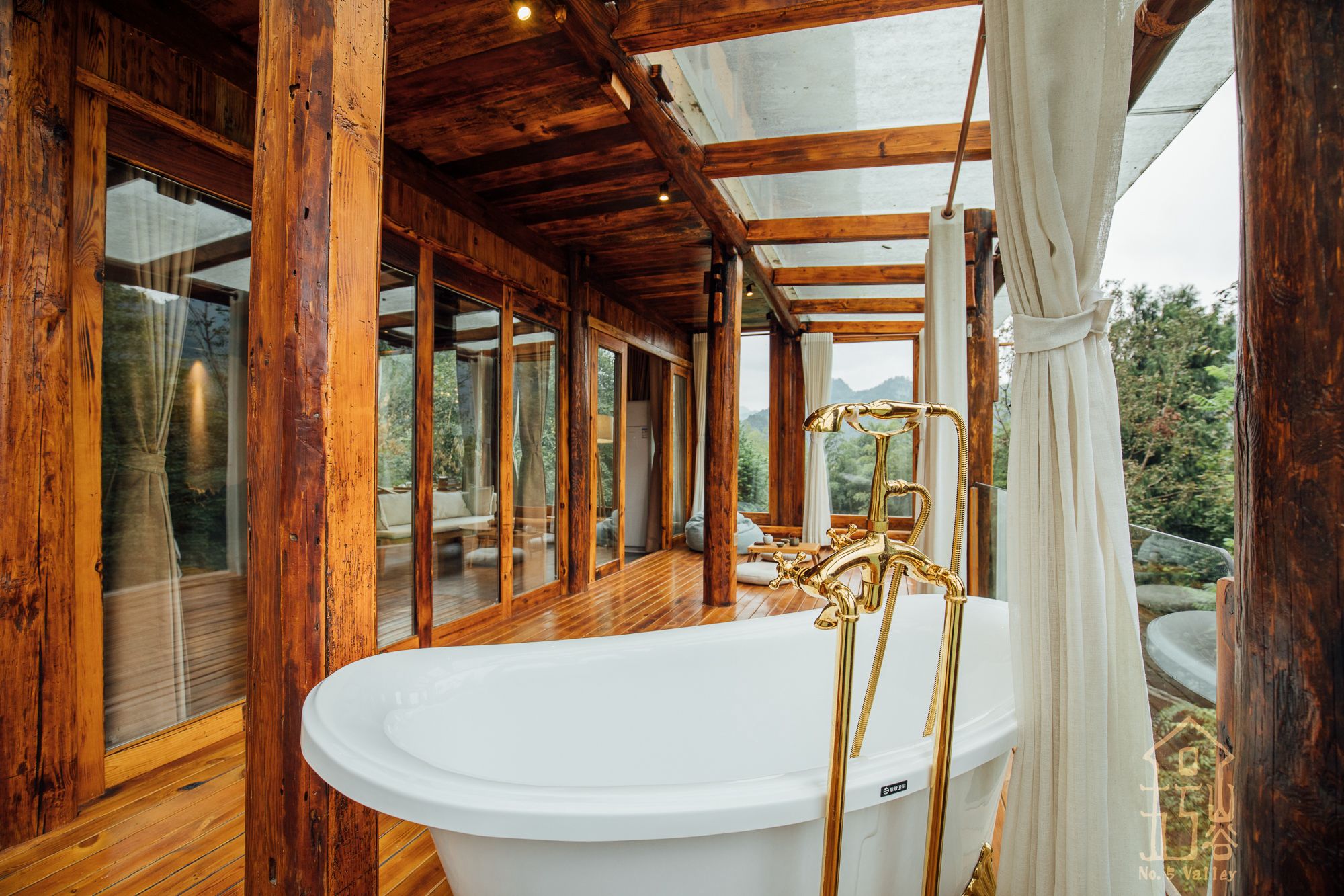 Una cabaña de madera con una bañera grande y vistas al exterior.