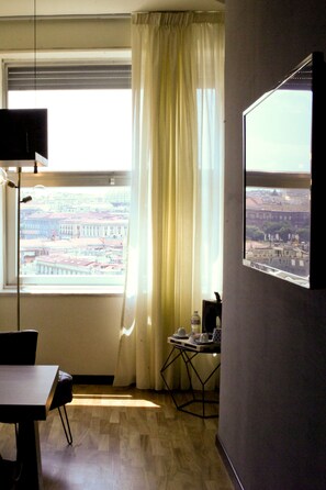 A room with a large window, a table, and a chair.