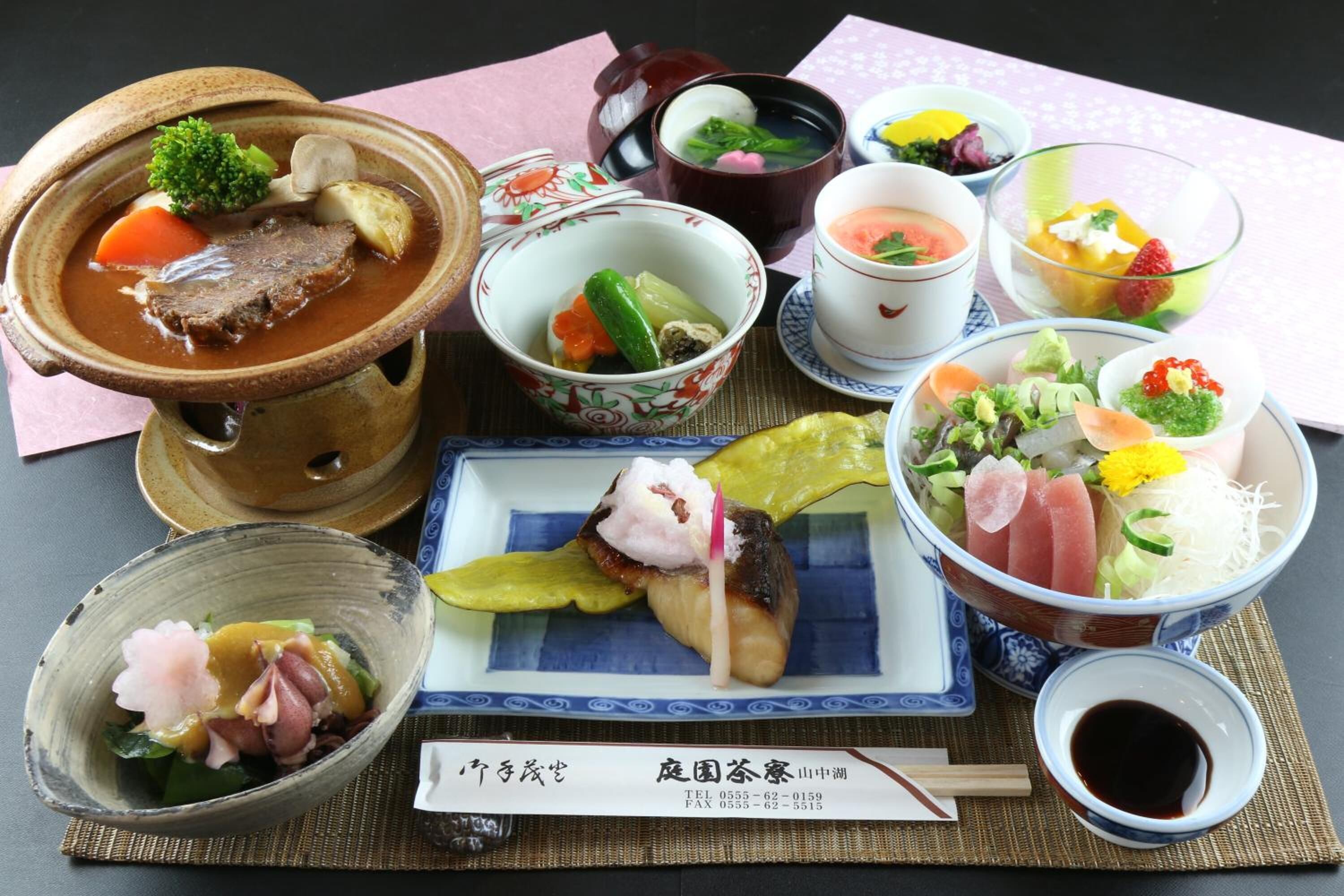 Diversos pratos japoneses, incluindo uma tigela de sopa, sashimi e outros petiscos.