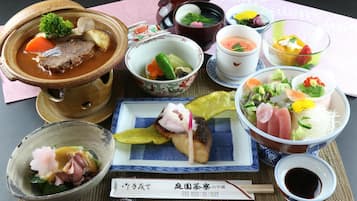 Diversos pratos japoneses, incluindo uma tigela de sopa, sashimi e outros petiscos.