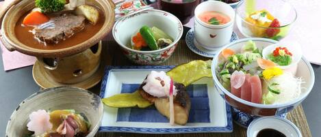 A variety of Japanese dishes including a bowl of soup, sashimi, and other small plates of food.