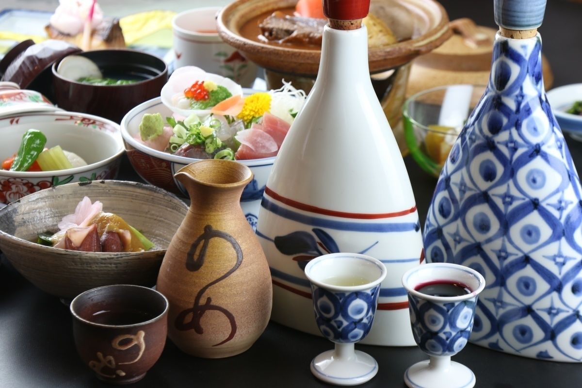 A variety of traditional Japanese dishes and ceramics, including a teapot, a cup, and a bowl with food.