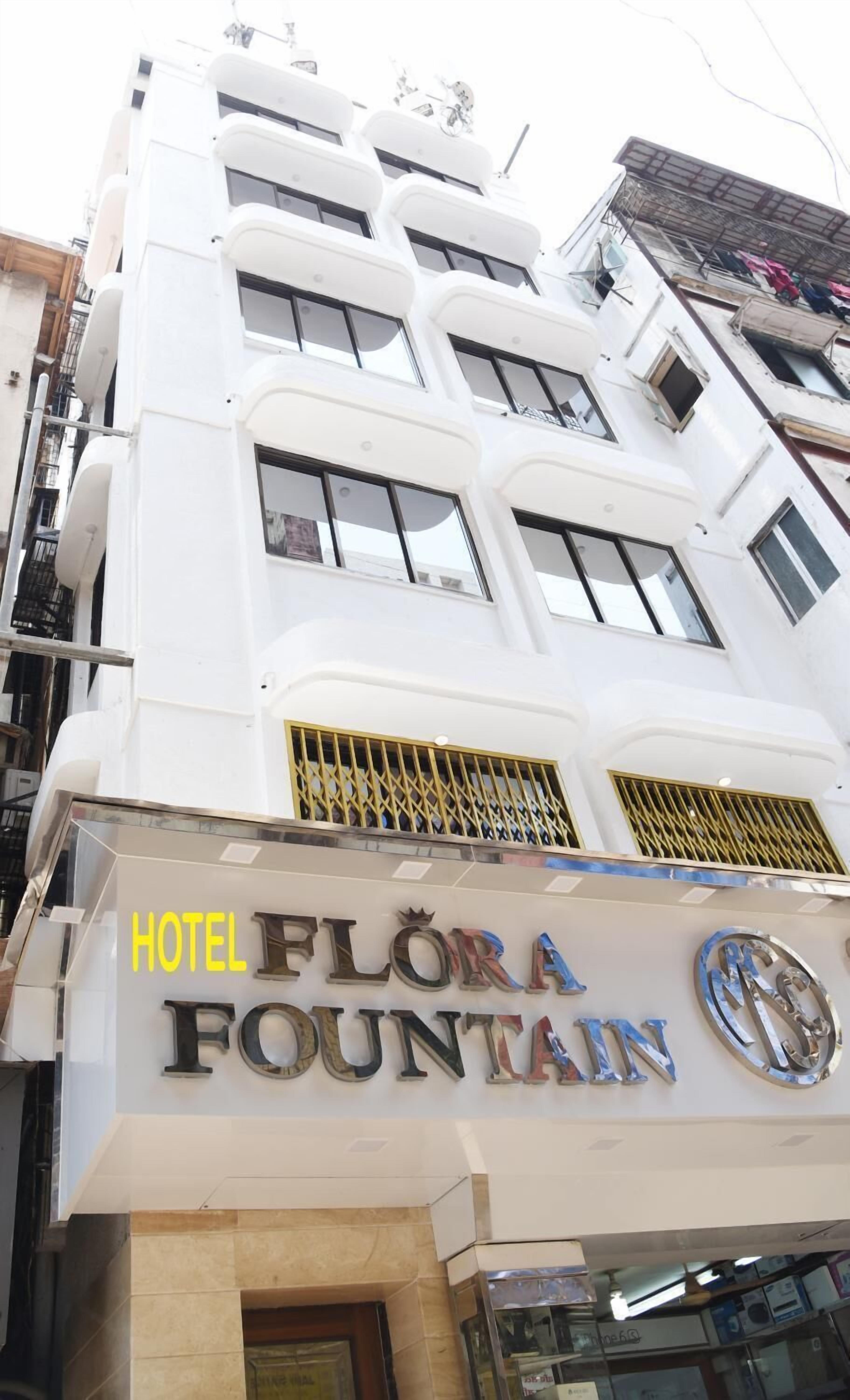 Ein mehrstöckiges Gebäude mit einem Schild für "Hotel Flora Fountain".