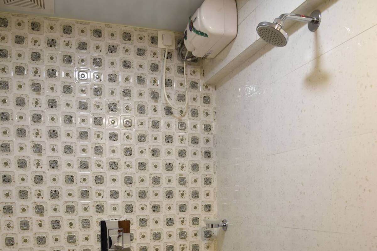 A bathroom with a toilet, a shower, and a sink.