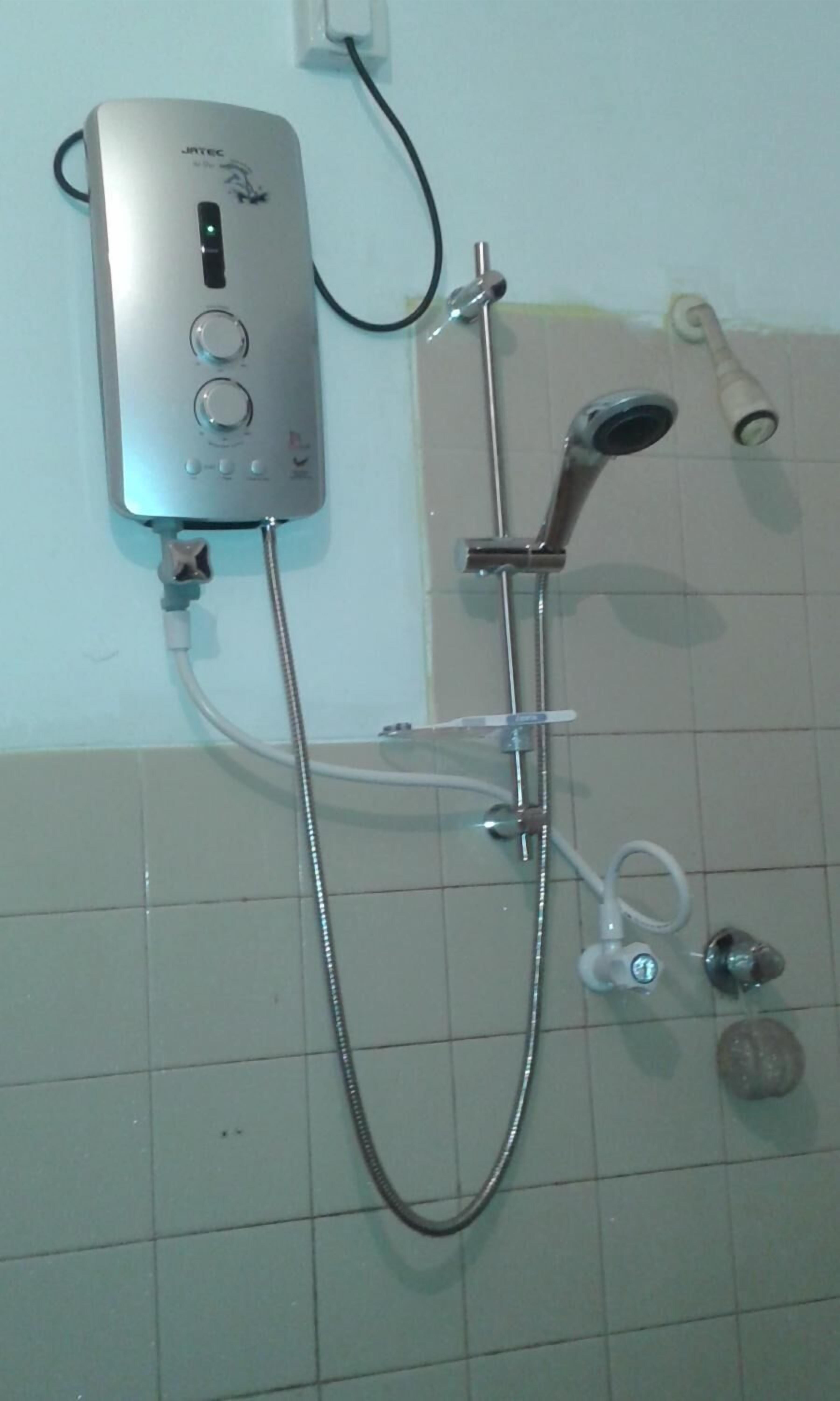 A shower unit with a control panel, a handheld showerhead, and a handheld massager.