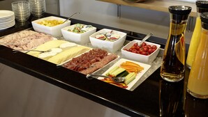 A buffet with various food items including meats, cheeses, fruits, and vegetables. - Hotel St Josef (Zürich)