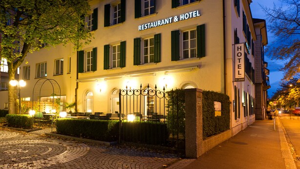 A building labeled "RESTAURANT & HOTEL" with a paved entrance and a gated patio area. - Hotel St Josef (Zürich)