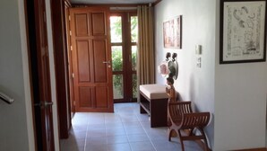 A hallway with a wooden door, a bench, and a chair. - 3-Bedroom Villa TG11 on Beachfront Resort SDV280-By Samui Dream Villas (Koh Samui)