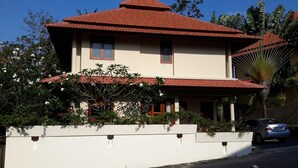 A two-story house with a red-tiled roof, a white exterior, and a car parked in the driveway. - 3-Bedroom Villa TG11 on Beachfront Resort SDV280-By Samui Dream Villas (Koh Samui)