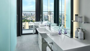 A modern bathroom with two sinks, a large mirror, and a view of a cityscape through floor-to-ceiling windows. - YOTEL Singapore Orchard Road (Singapore)
