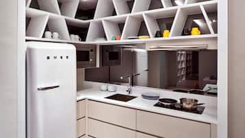 A modern kitchen with white cabinetry, a built-in microwave, and a stainless steel sink.