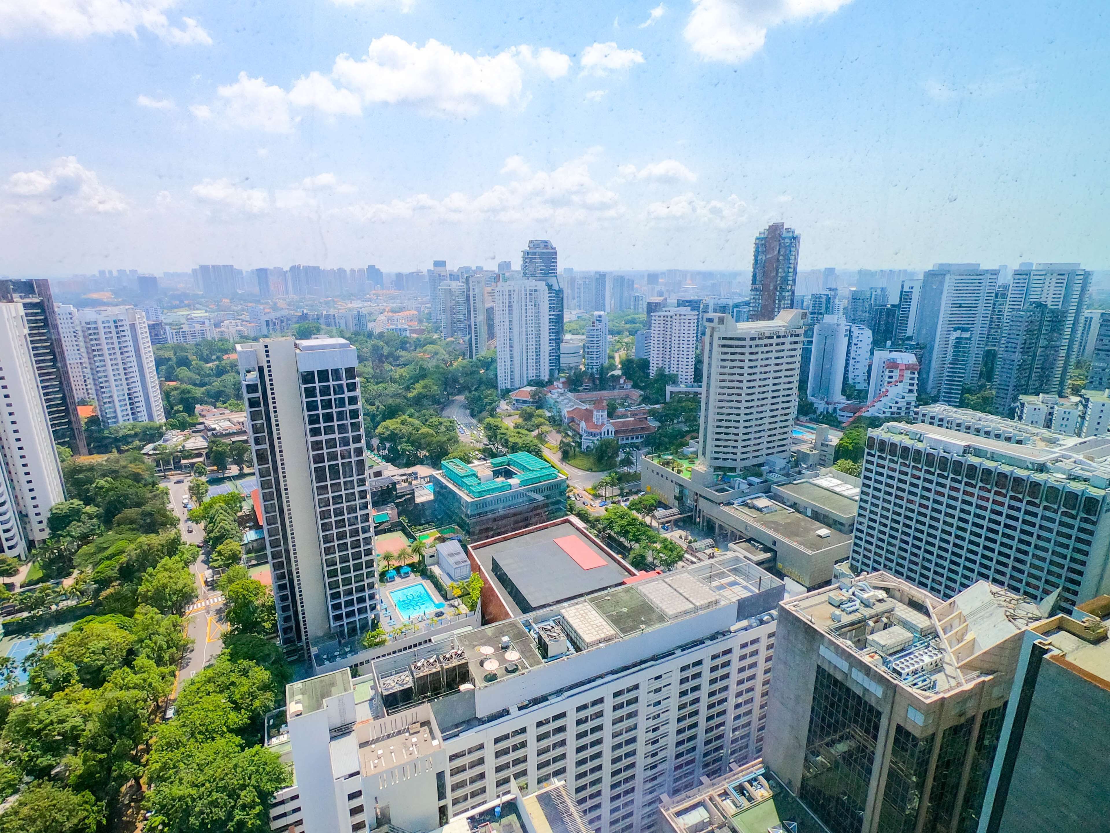 A high-rise building with multiple floors, surrounded by other high-rise buildings and greenery.