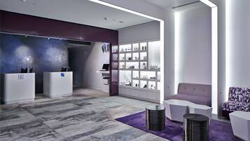 Welcome to our reception area, featuring a digital display, comfortable seating, and a display case showcasing local treasures.