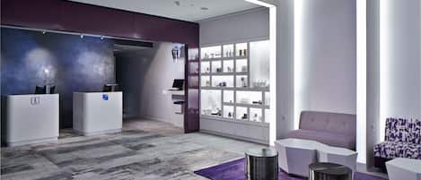 A modern reception area with a reception desk, seating area, and a display of products.