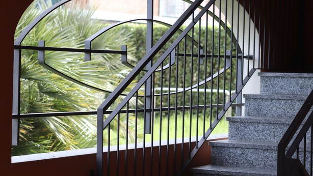 Una escalera con barandilla metálica que lleva a una plataforma.