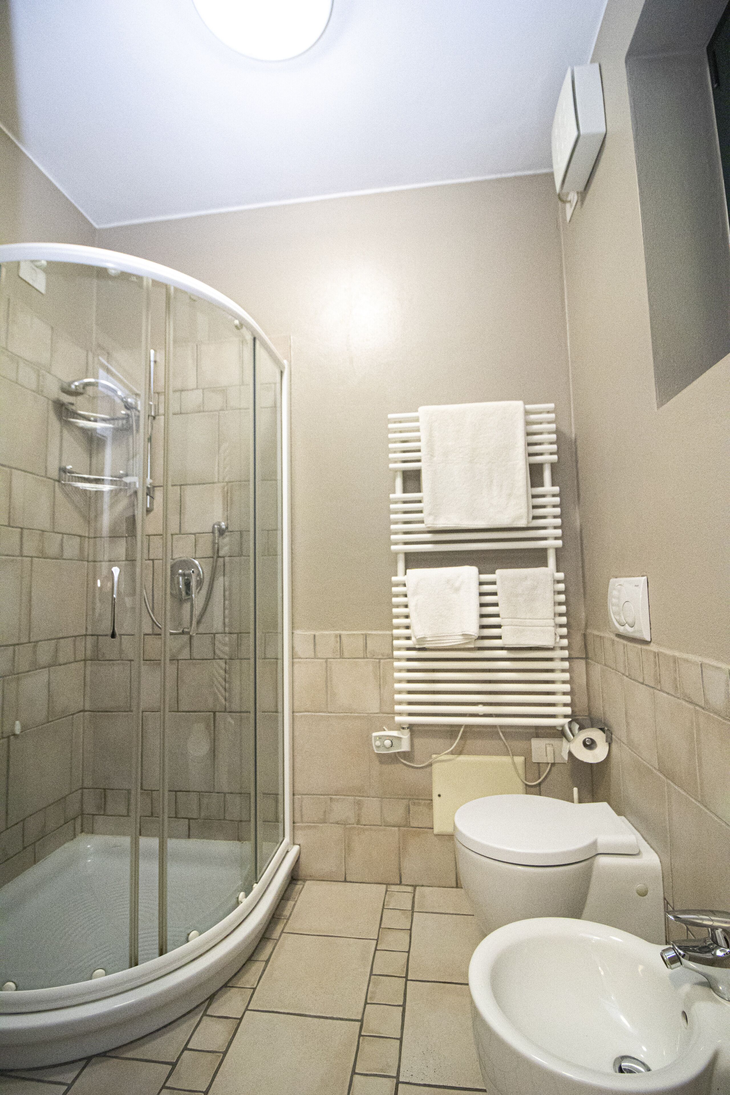 Ein Badezimmer mit Duschkabine, Toilette und Waschbecken.