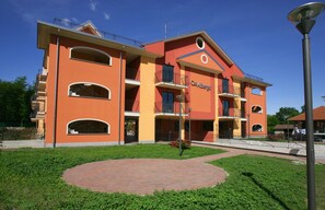 A multi-story hotel with balconies, a central courtyard, and a clear blue sky. - LVG Hotel Collection – Casalbergo (Castelletto Sopra Ticino)
