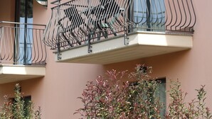 Un edificio de varios pisos con balcones, cada uno con un toldo a rayas.
