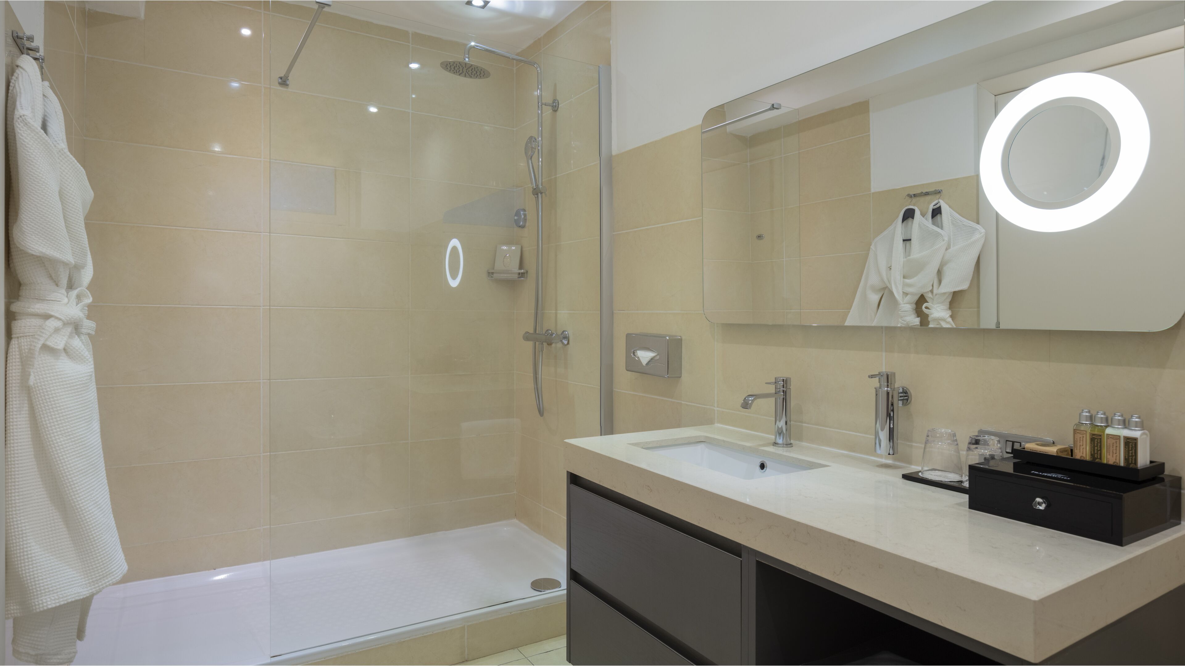 A modern bathroom with a glass-enclosed shower, a vanity with a mirror, and a bathtub.