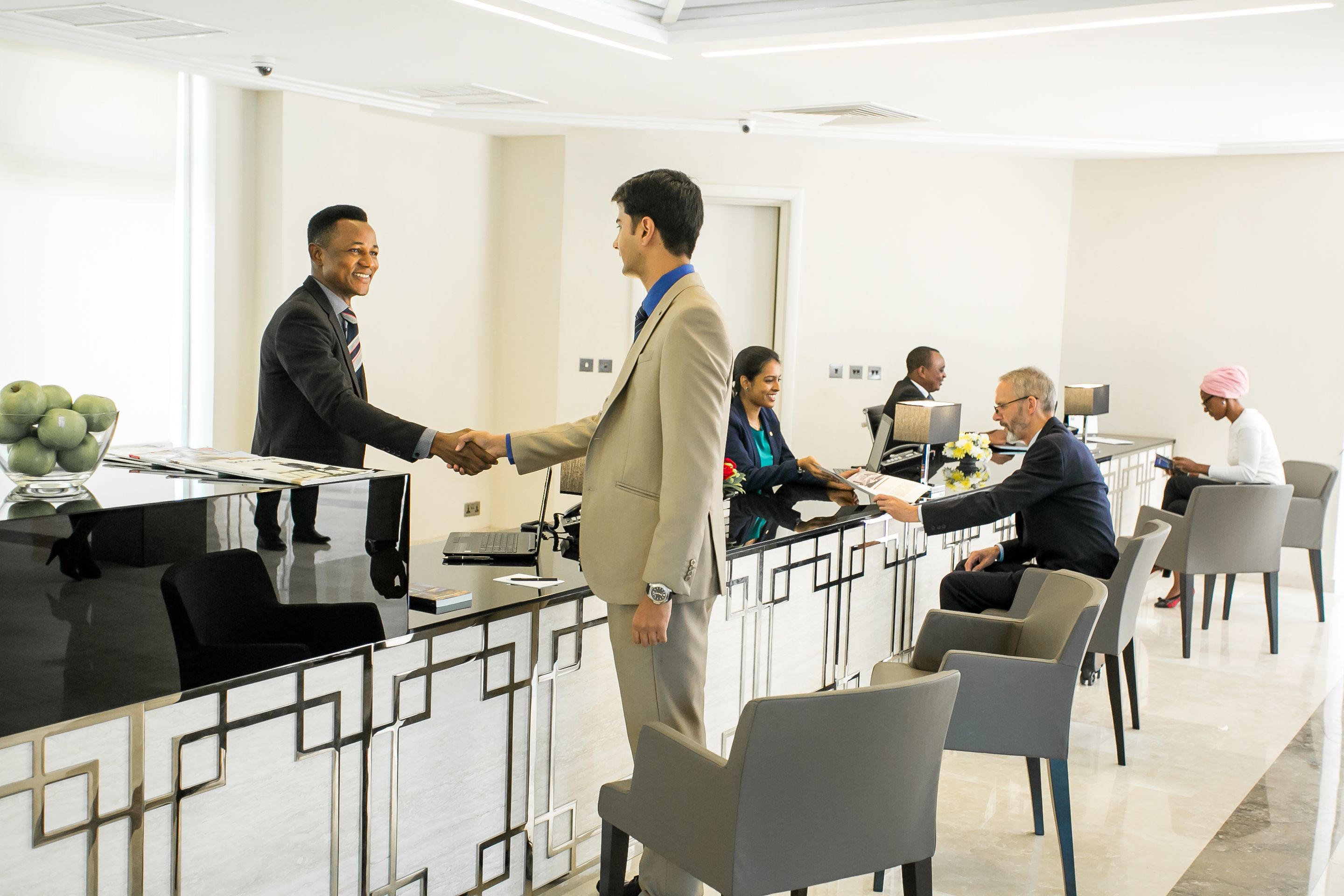 A modern conference room with a long table, several chairs, and a reception desk.