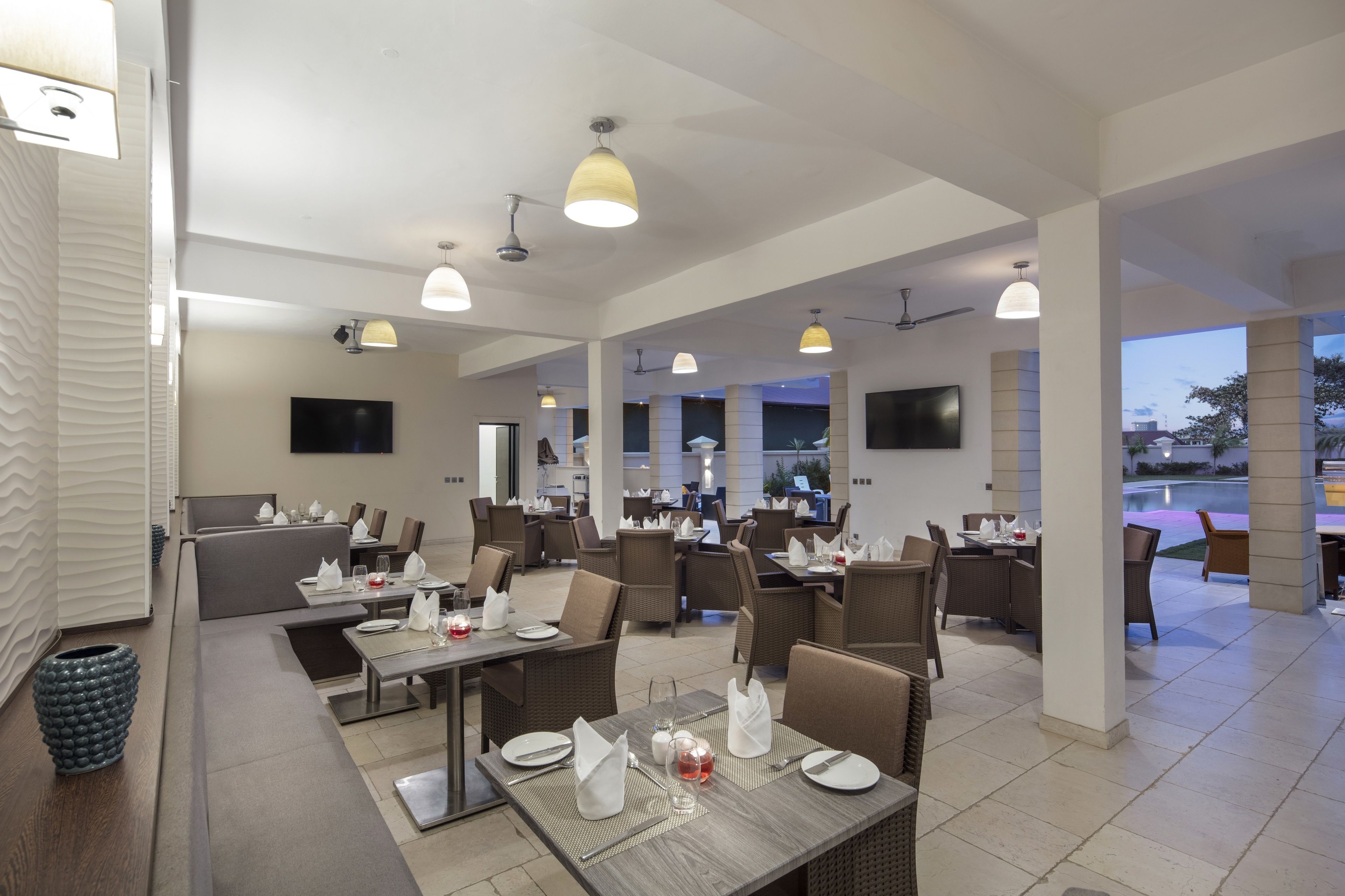 A modern restaurant with multiple dining areas, including a bar and a private dining section.