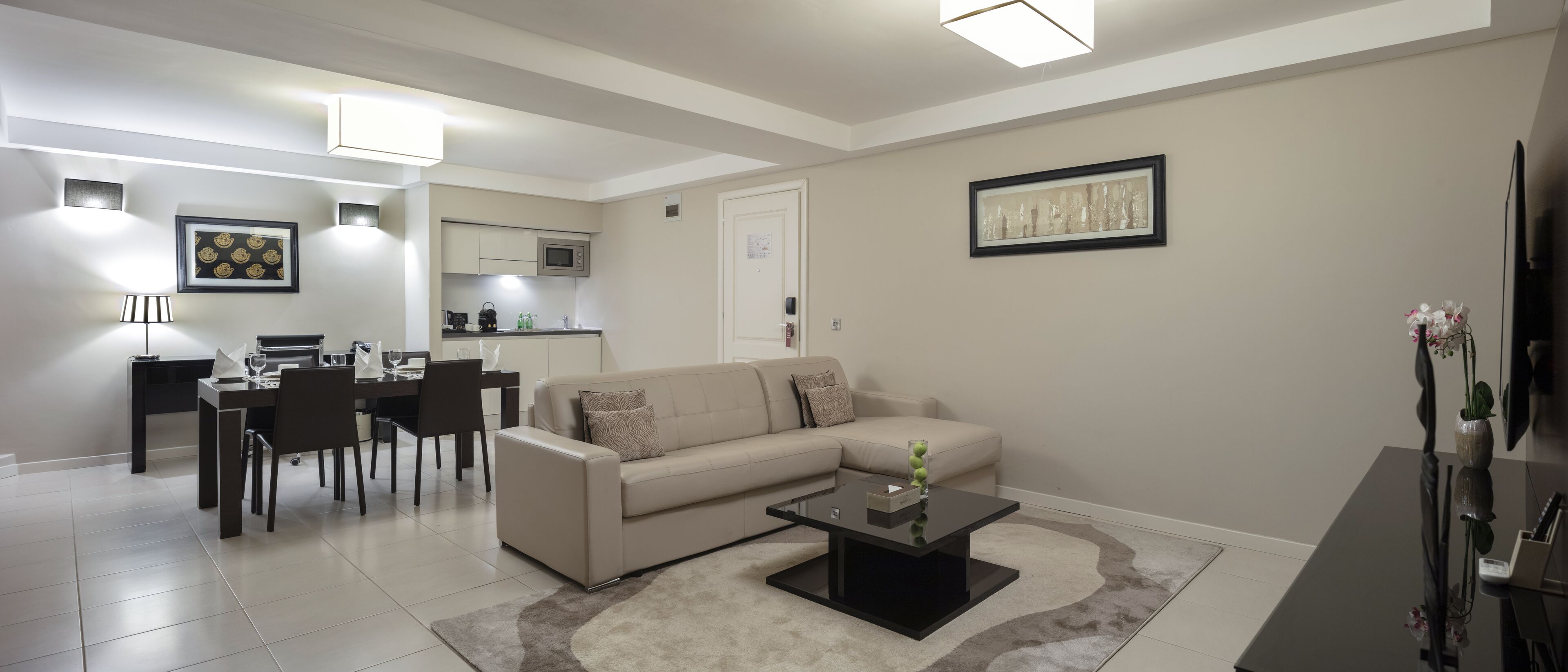 A modern living room with a sofa, coffee table, and dining area.