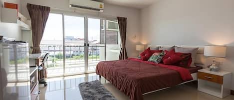 Un dormitorio moderno con una cama grande, una mesita de noche, un aparador y una ventana con cortinas.