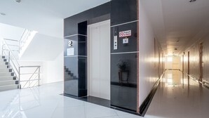 A modern hotel lobby with a staircase, a 'No Smoking' sign, and a clean, reflective floor. - Taweesuk Residence (Samut Sakhon)