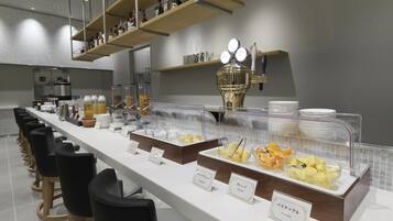 A buffet setup with various food items and a beverage station.