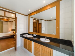 A modern bathroom with a large mirror, two sinks, and wooden cabinets. - 3 Bedroom Villa Beach Front Resort TG12 (Koh Samui)