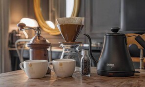 A coffee-making setup with a grinder, a coffee press, and two cups on a table. - February Hotel The Signature Dongseongro (Daegu)