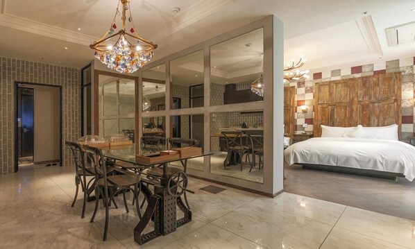 Une chambre d’hôtel comprenant un coin repas, un lit et un grand miroir.