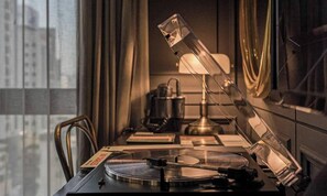 A room with a desk, a lamp, a record player, and a window with curtains. - February Hotel The Signature Dongseongro (Daegu)