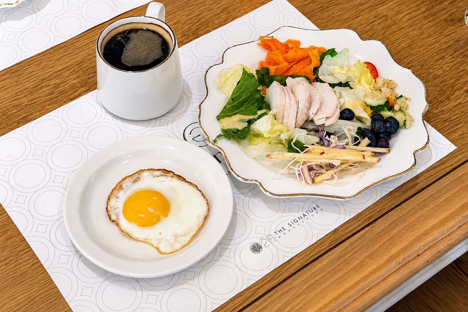 A breakfast setting with a plate of food, a cup of coffee, and a placemat.
