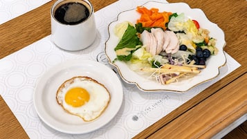 A breakfast setting with a plate of food, a cup of coffee, and a placemat.
