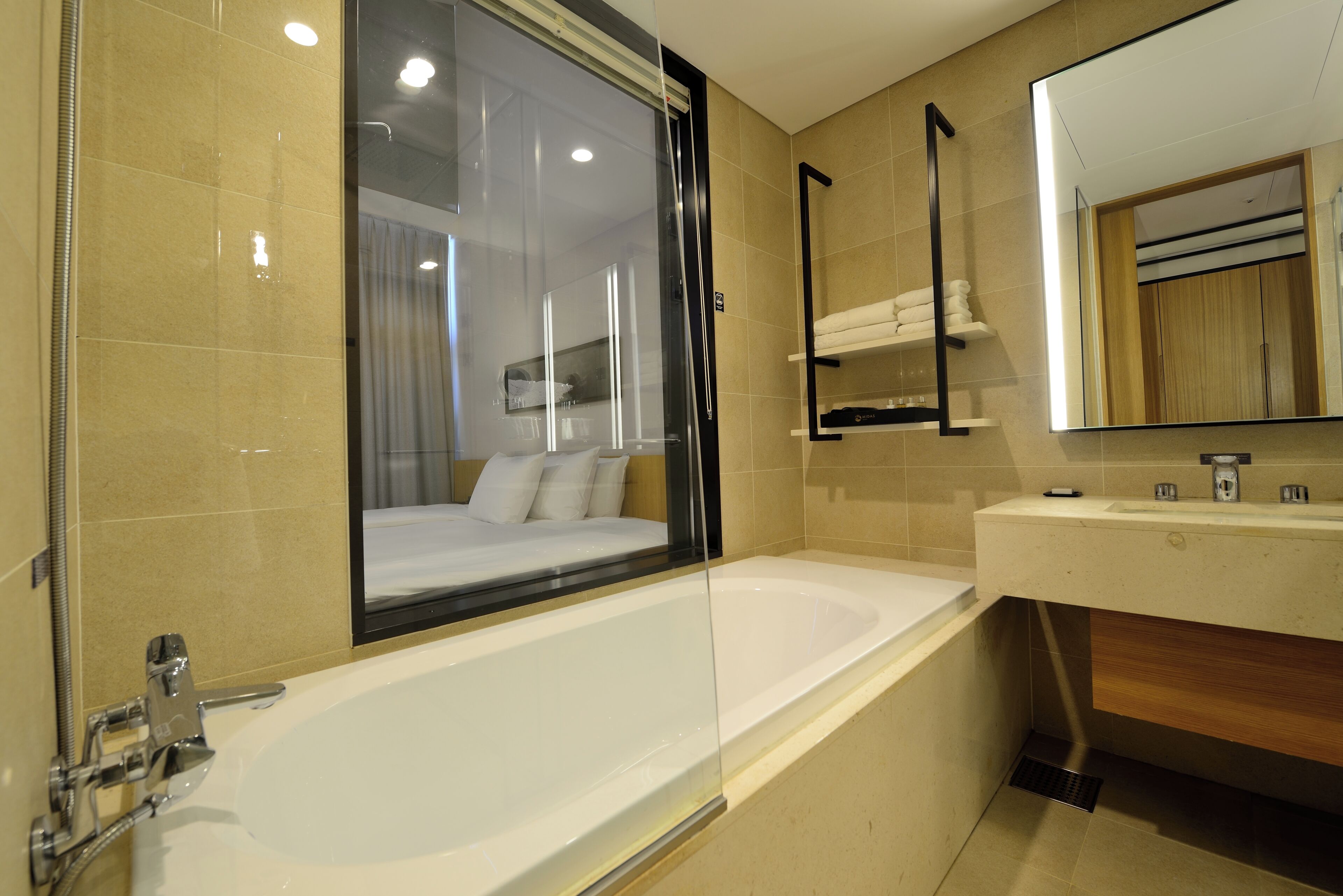 Een moderne badkamer met een groot bad, een douchecabine van glas en een houten wastafelmeubel.