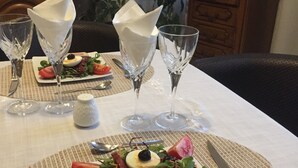 Mesa lista para comer, con un sándwich, ensalada y copas de vino.