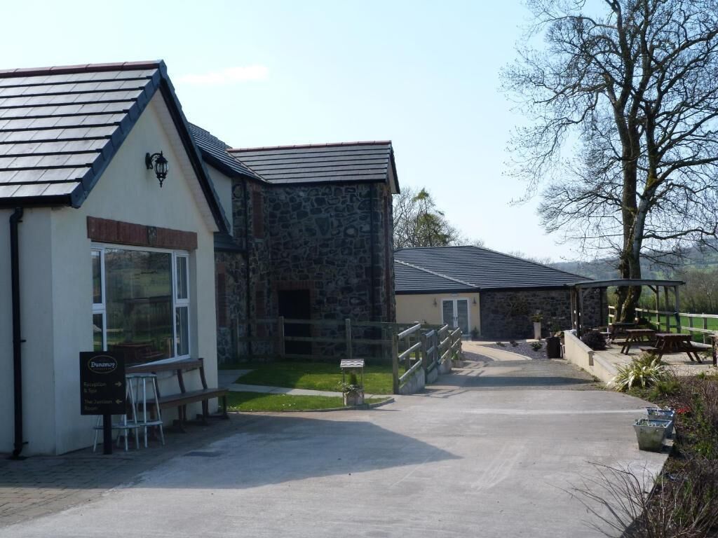 A building with a stone facade, a wooden bench, and a paved entrance.