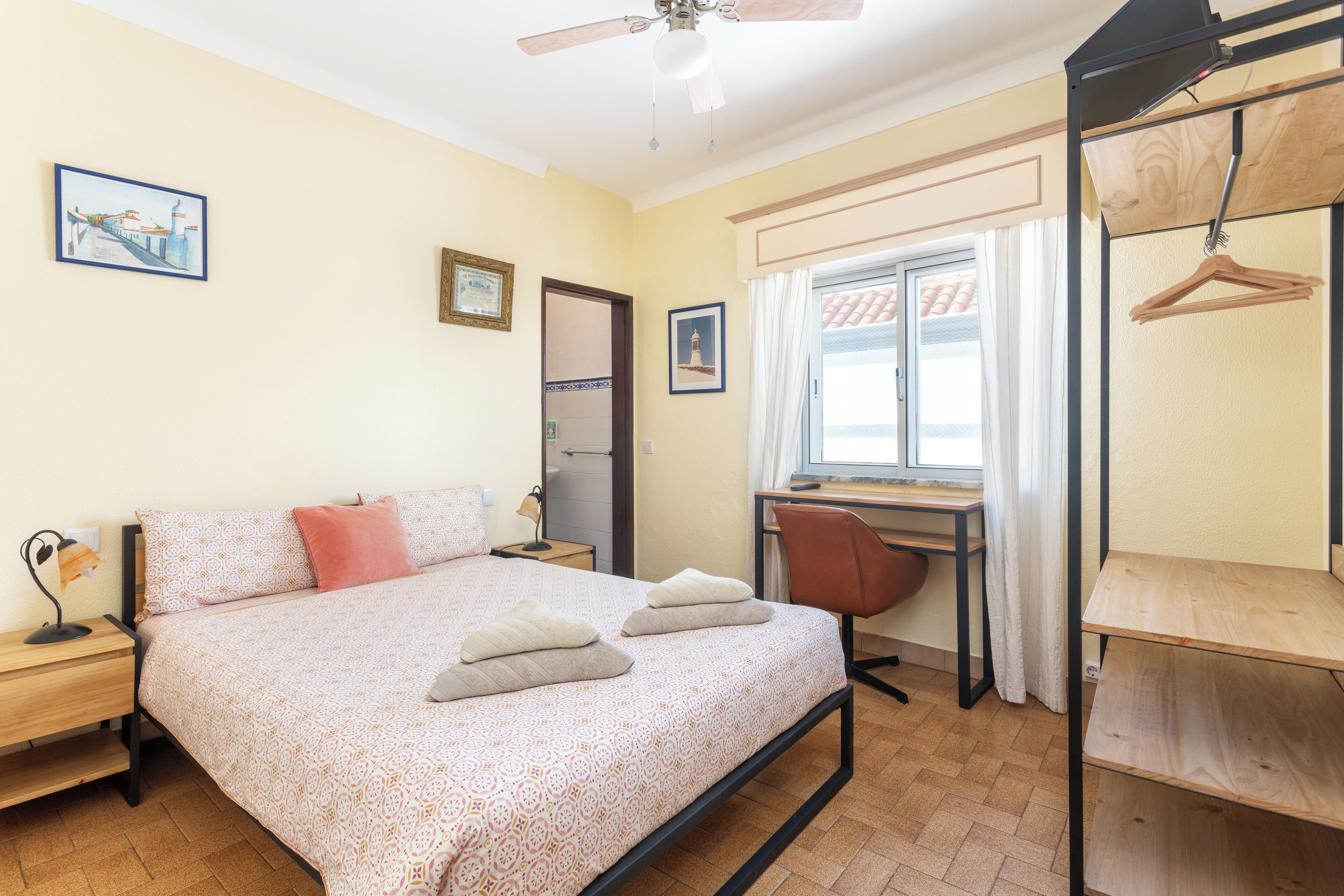 Ein Schlafzimmer mit Bett, Schreibtisch, Stuhl und Kleiderschrank.