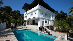 A modern two-story house with a swimming pool, surrounded by lush greenery and palm trees. - Lavenro Hotel & Resort (Deniyaya)