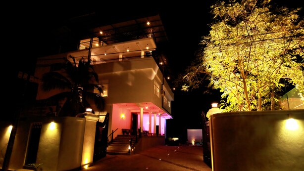 A multi-story building with a well-lit entrance and a staircase leading to the upper levels. - Lavenro Hotel & Resort (Deniyaya)