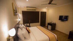 A hotel room with a bed, bedside table, TV, wardrobe, and an air conditioning unit. - Hotel Ashok Residency (Chennai)