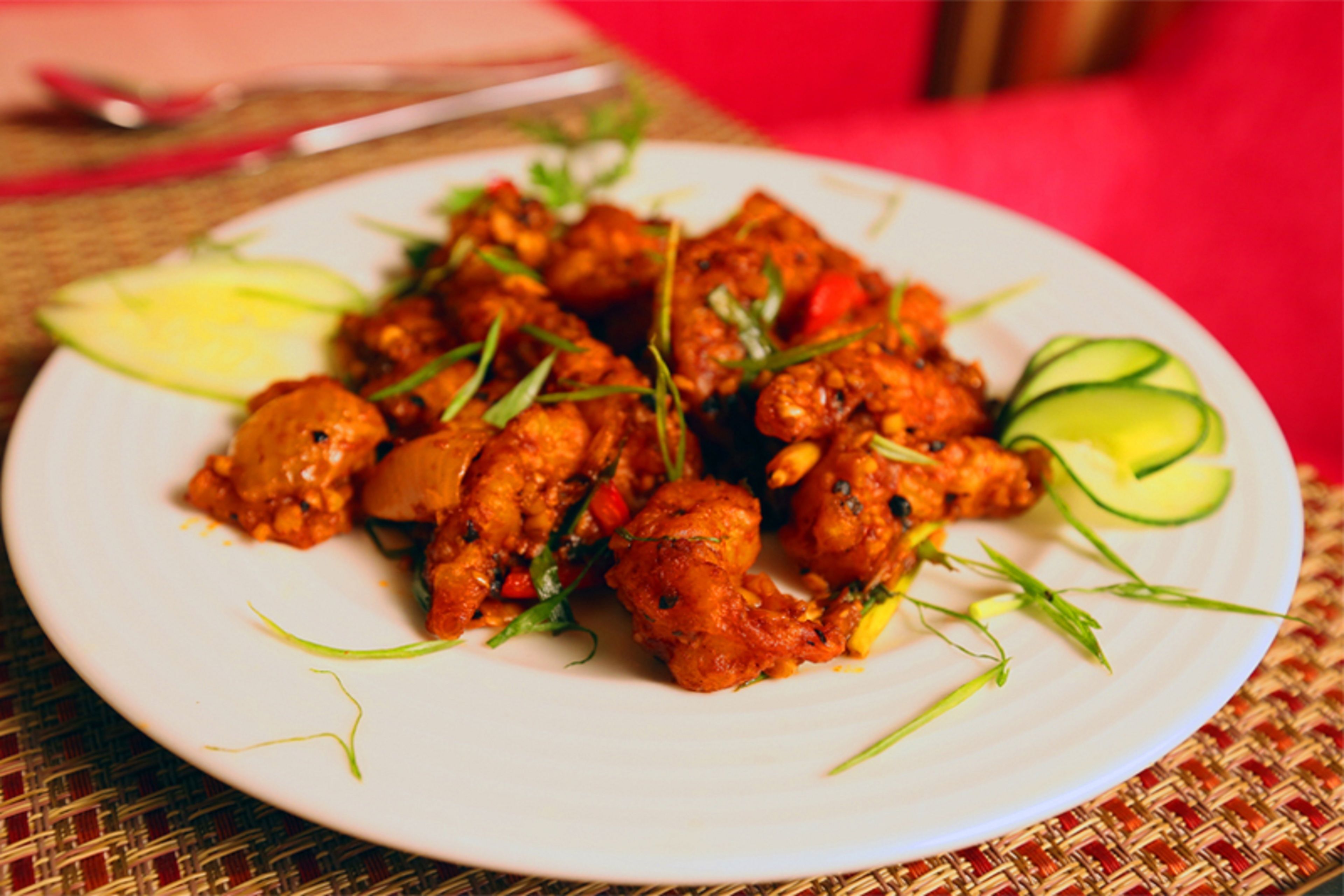A plate of food garnished with herbs and slices of cucumber.