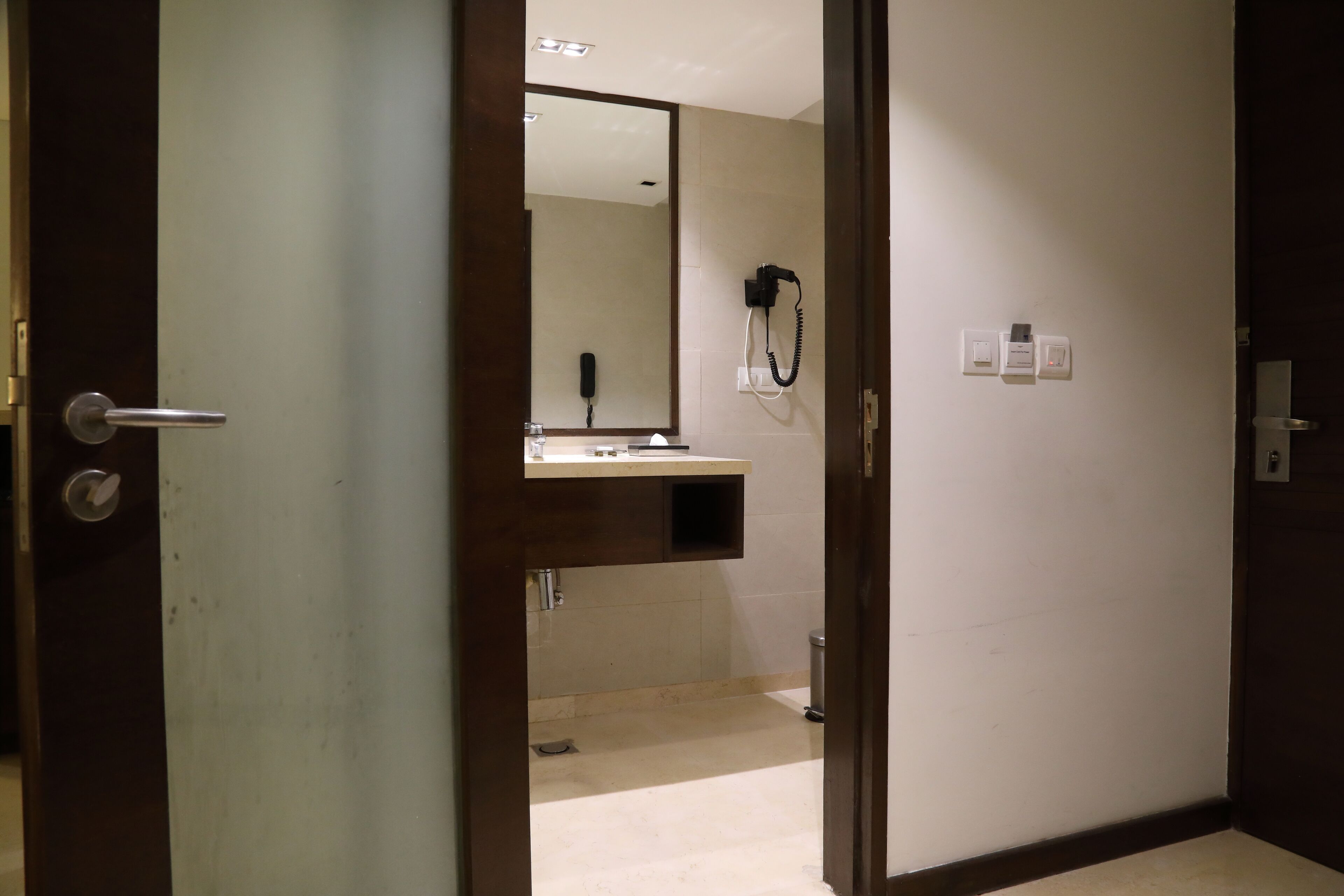 Une salle de bain d’hôtel avec un miroir, un lavabo et un téléphone.