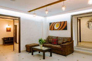 Relax in this stylish living room with a leather sofa, ottoman, and glass coffee table.