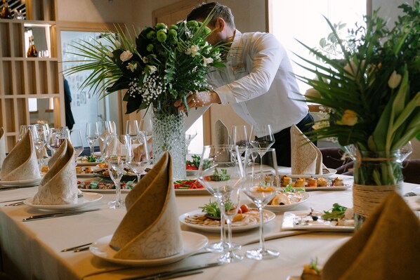 Enjoy a beautifully set table with fine china, fresh flowers, and a wine glass, perfect for a memorable dining experience.