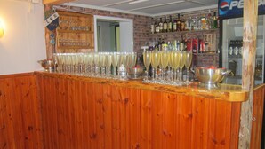 A bar area with wooden paneling, a variety of bottles, and a Pepsi refrigerator. - Sikhalls Camping och Restaurang (Bralanda)