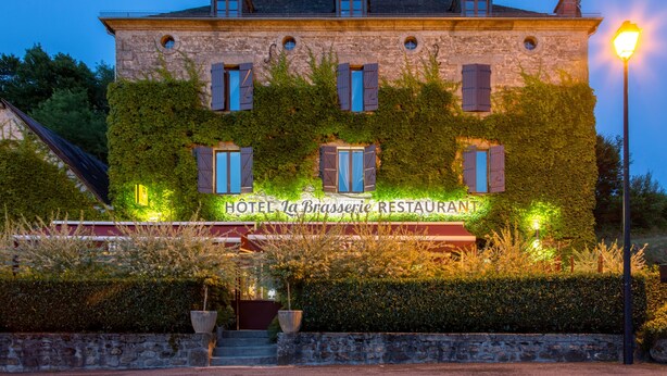 A stone building with a sign reading "HOTEL La Brasserie RESTAURANT" and ivy-covered walls. - Hôtel de la Brasserie de Treignac (Treignac)