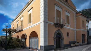 A two-story building with a symmetrical facade, arched windows, and a central entrance with a decorative arch. - Sorrento Coast Relais (Meta)