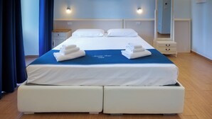 A hotel room with a large bed, two bedside tables, a nightstand, a dresser, a mirror, and a painting on the wall. - Sorrento Coast Relais (Meta)